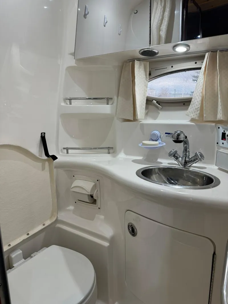 Slide: The Image of 2005 Chaparral Signature 310 bathroom with sink, toilet, and storage cabinets. - 27