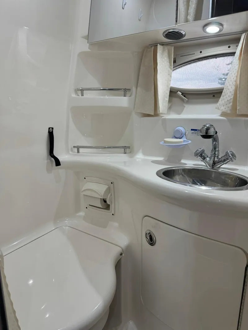 Slide: The Image of 2005 Chaparral Signature 310 bathroom with sink, toilet, and storage shelves. - 29