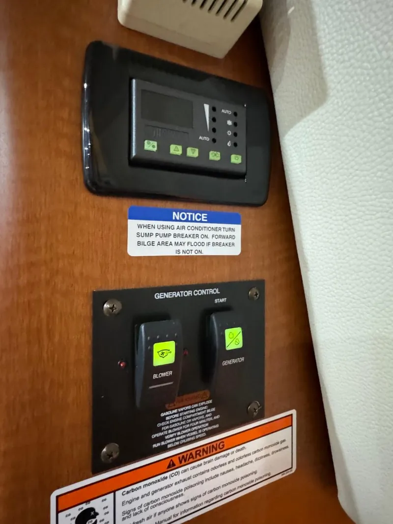 Slide: The Image of Control panel of a 2005 Chaparral Signature 310 boat with generator controls and warning labels. - 40