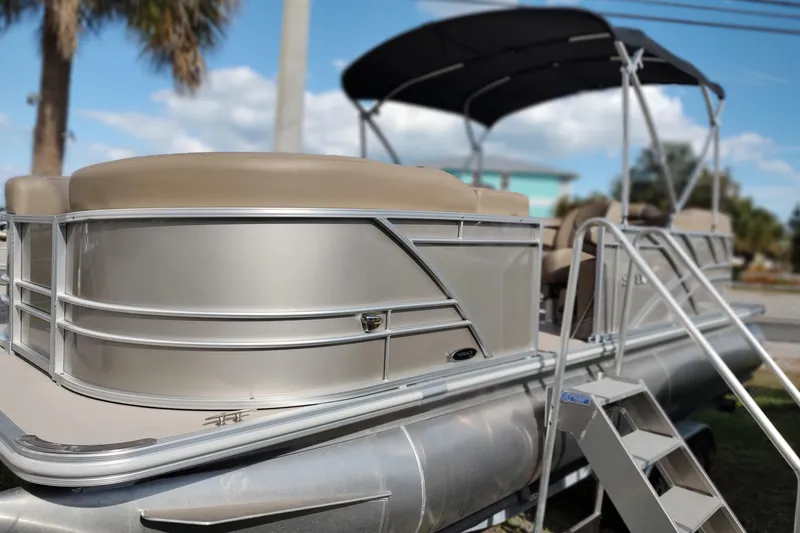 Slide: The Image of 2025 Sylvan Mirage 822 LZ pontoon boat with canopy and seating, parked outdoors. - 18