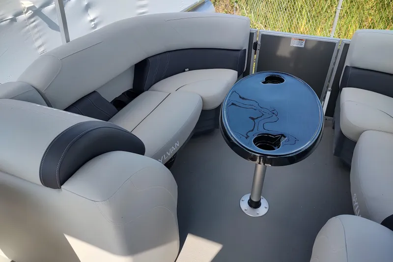 Slide: The Image of 2025 Sylvan Mirage 822 LZ pontoon boat interior with plush seating and sleek table. - 11