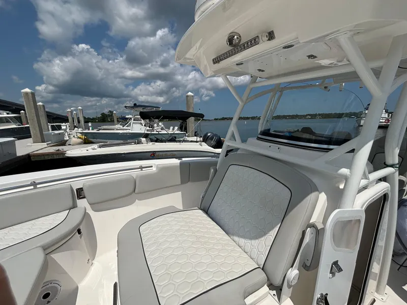 Slide: The Image of 2021 Sea Fox 288 Commander boat interior with cushioned seating at a marina. - 14