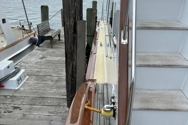 Slide: The Image of 1986 Wilbur Hunt Yachts docked, showing wooden deck and side view with steps. - 12