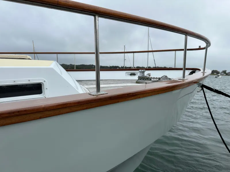 Slide: The Image of 1986 Wilbur Hunt Yachts boat with wooden railings docked on a cloudy day. - 13