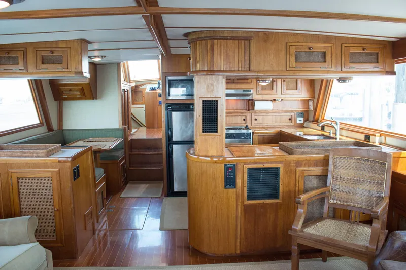 Slide: The Image of 1986 Wilbur Hunt Yachts interior with wooden cabinetry, kitchen, and seating area. - 14