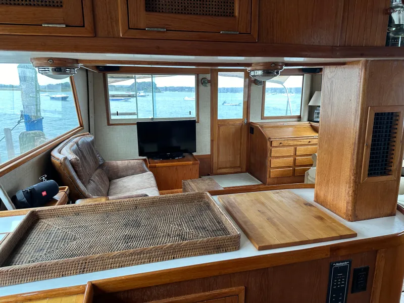 Slide: The Image of Interior of 1986 Wilbur Hunt Yachts with wood finish, seating, and waterfront view. - 15
