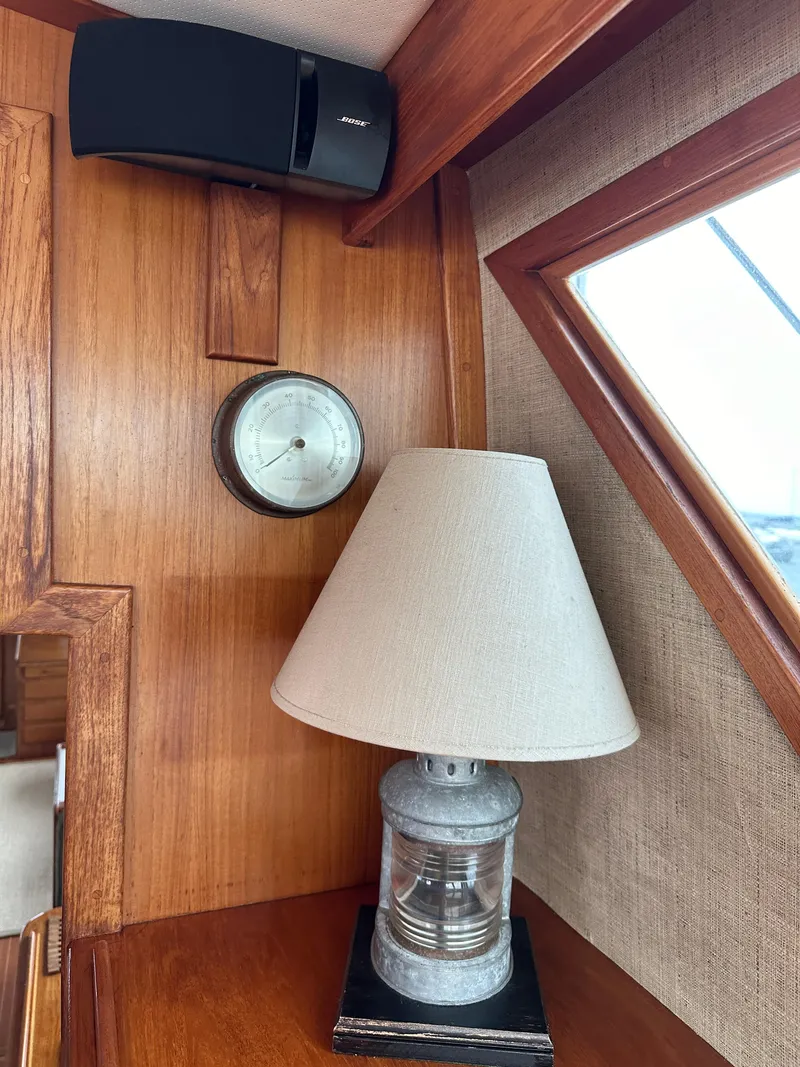 Slide: The Image of 1986 Wilbur Hunt Yachts interior with lamp, clock, and speaker on wooden paneling. - 17