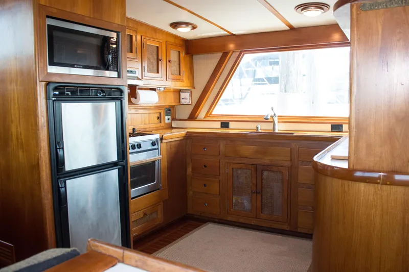 Slide: The Image of 1986 Wilbur Hunt Yachts kitchen interior with wood cabinetry, stainless appliances, and large window. - 19