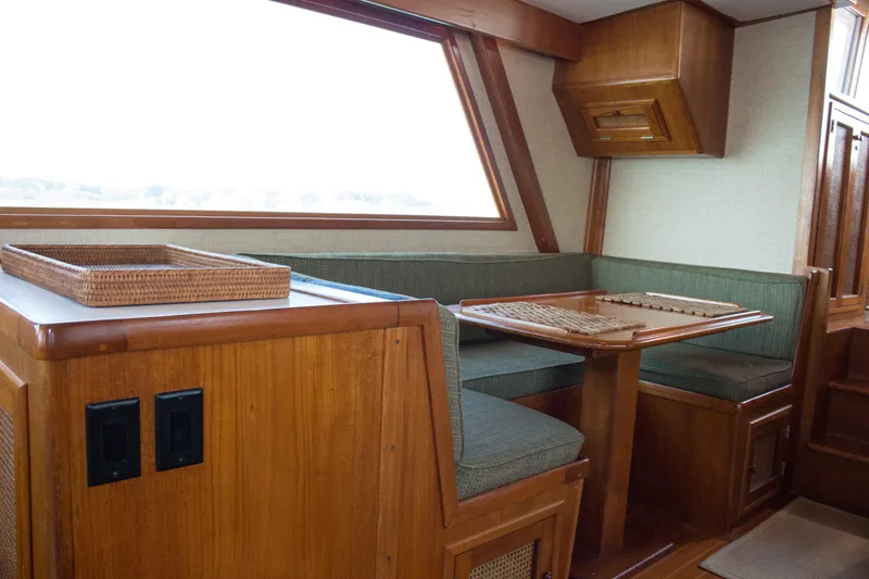 Slide: The Image of 1986 Wilbur Hunt Yachts interior with wooden dining area and green cushioned seating. - 20