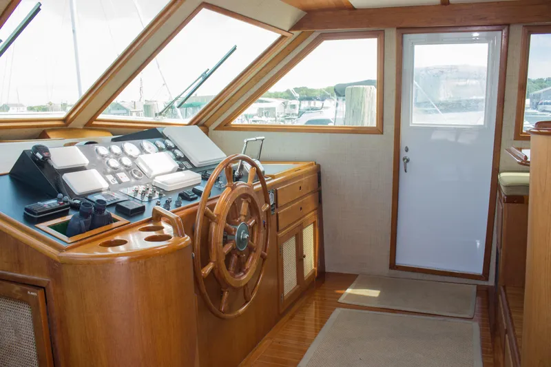 Slide: The Image of 1986 Wilbur Hunt Yachts helm with wooden steering wheel and control panel. - 22