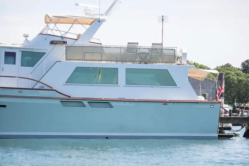 Slide: The Image of 1986 Wilbur Hunt Yachts boat docked on calm water, featuring a sleek design and spacious deck. - 3