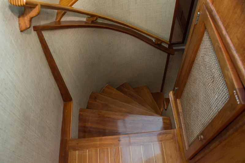Slide: The Image of Wooden spiral staircase inside 1986 Wilbur Hunt Yachts, featuring elegant handrails and cabinetry. - 33