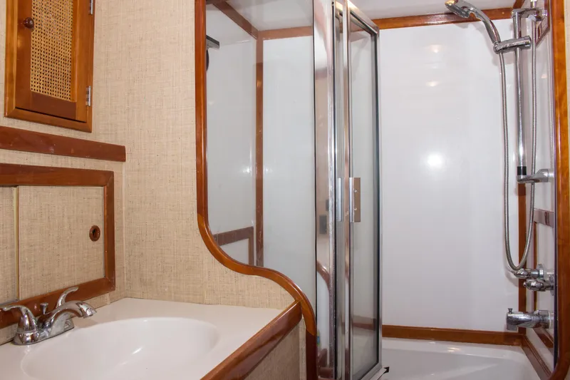 Slide: The Image of 1986 Wilbur Hunt Yachts bathroom with sink, shower, and wooden accents. - 36