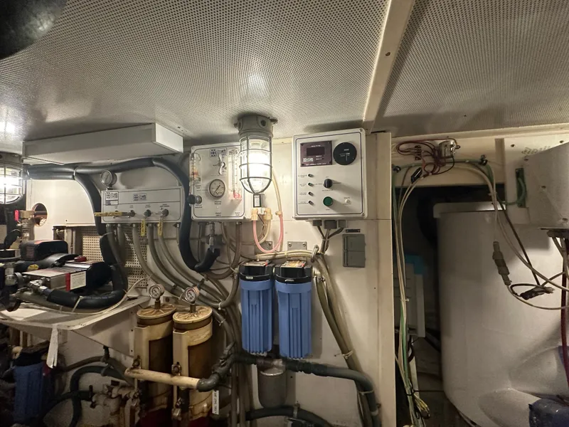 Slide: The Image of Engine room of 1986 Wilbur Hunt Yachts, featuring control panels and filtration systems. - 45