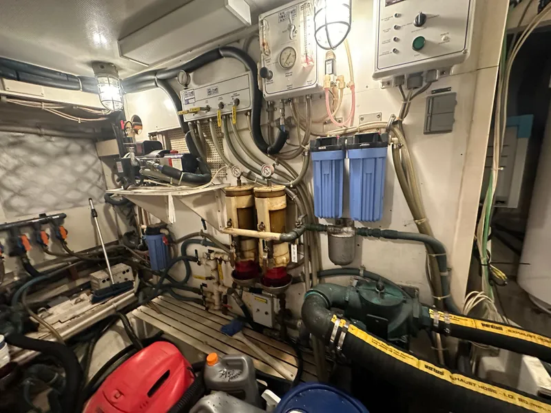 Slide: The Image of Engine room of a 1986 Wilbur Hunt Yacht with various mechanical components and equipment. - 46