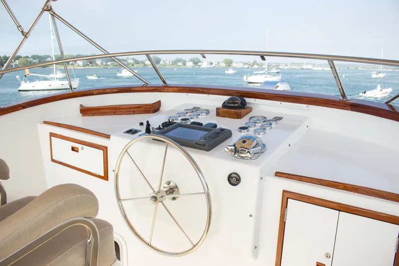 Slide: The Image of Helm of 1986 Wilbur Hunt Yachts boat with steering wheel and control panel, overlooking water. - 5