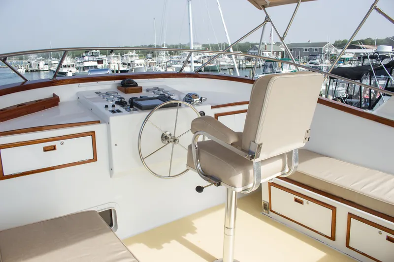 Slide: The Image of Captain's chair and helm on 1986 Wilbur Hunt Yachts, overlooking marina with boats. - 6