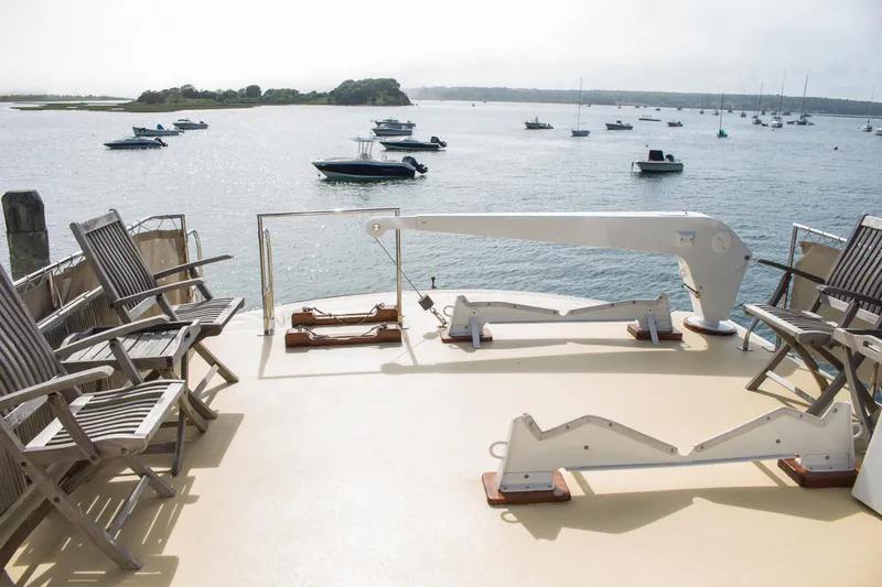 Slide: The Image of Deck of 1986 Wilbur Hunt Yacht with chairs overlooking serene harbor and anchored boats. - 7