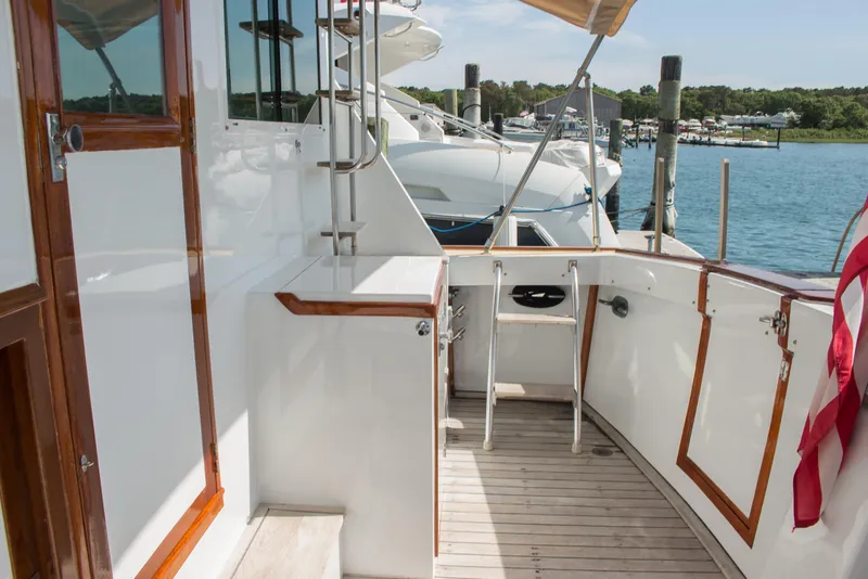 Slide: The Image of 1986 Wilbur Hunt Yachts deck with wooden accents, docked by the water. - 8