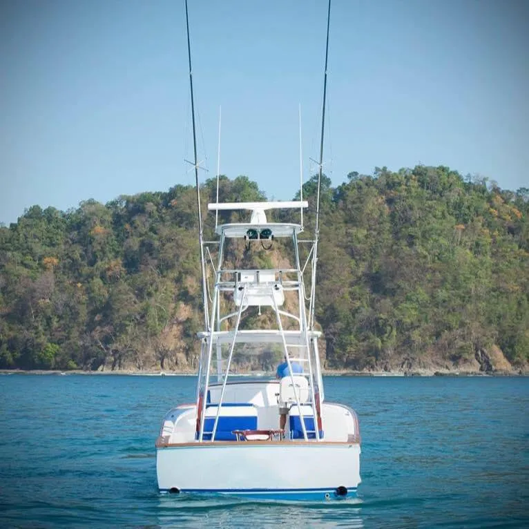 Slide: The Image of 2025 Maverick Yachts Costa Rica 36 Walkaround on serene water with lush forest backdrop. - 2