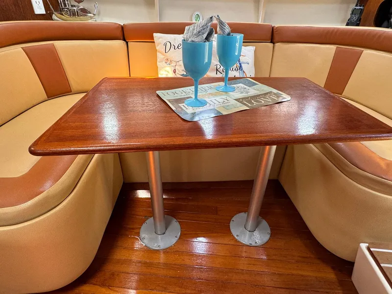 Slide: The Image of Interior of 2000 Tiara Yachts 3100 Open with wooden table and cushioned seating. - 10