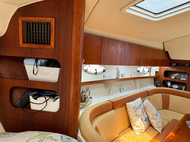 Slide: The Image of Interior of 2000 Tiara Yachts 3100 Open, featuring cozy seating and wooden cabinetry. - 16