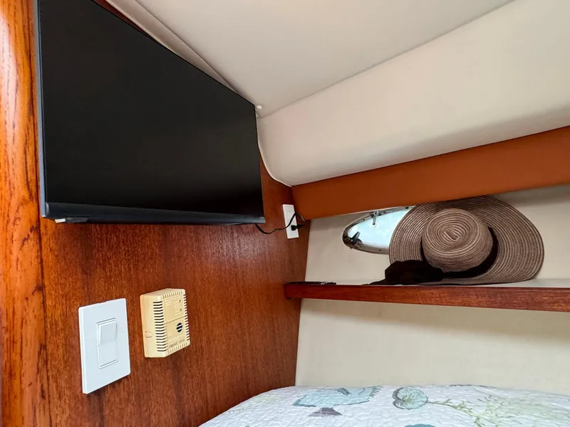 Slide: The Image of Interior of 2000 Tiara Yachts 3100 Open with TV, hat, and wooden accents. - 17