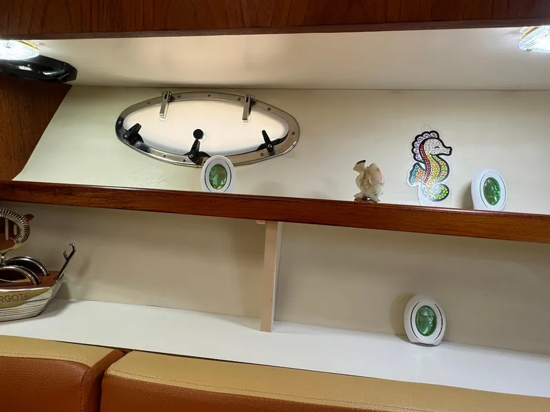 Slide: The Image of Interior of 2000 Tiara Yachts 3100 Open with decorative shelves and porthole. - 18