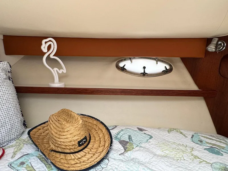 Slide: The Image of Cozy cabin interior of 2000 Tiara Yachts 3100 Open with straw hat and flamingo decor. - 19