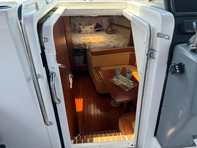 Slide: The Image of Interior view of 2000 Tiara Yachts 3100 Open, featuring cozy cabin and seating area. - 21