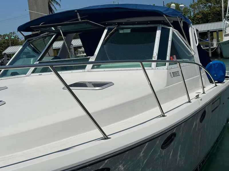 Slide: The Image of 2000 Tiara Yachts 3100 Open boat with blue canopy, docked in marina. - 29