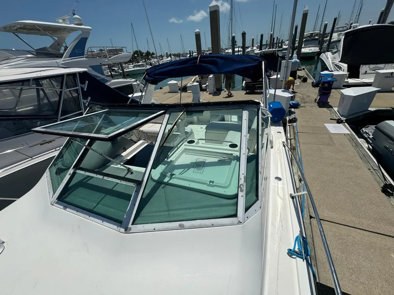 Slide: The Image of 2000 Tiara Yachts 3100 Open docked at marina under clear sky. - 30