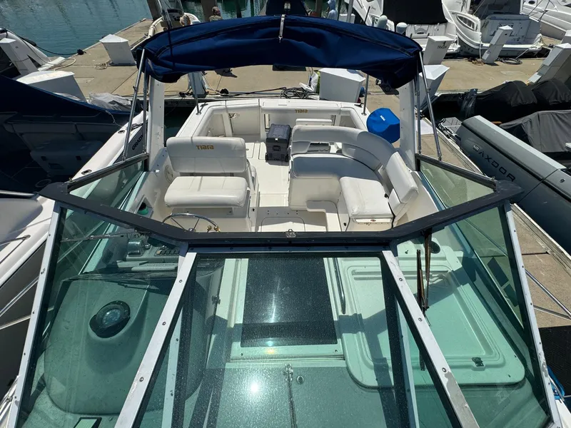 Slide: The Image of 2000 Tiara Yachts 3100 Open with spacious seating and blue canopy at marina. - 31