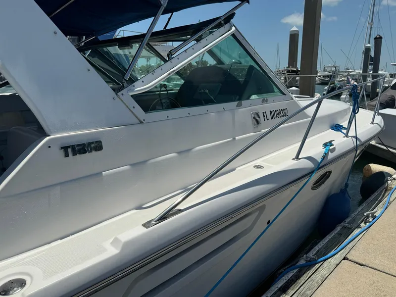 Slide: The Image of 2000 Tiara Yachts 3100 Open docked, featuring sleek design and white exterior. - 32