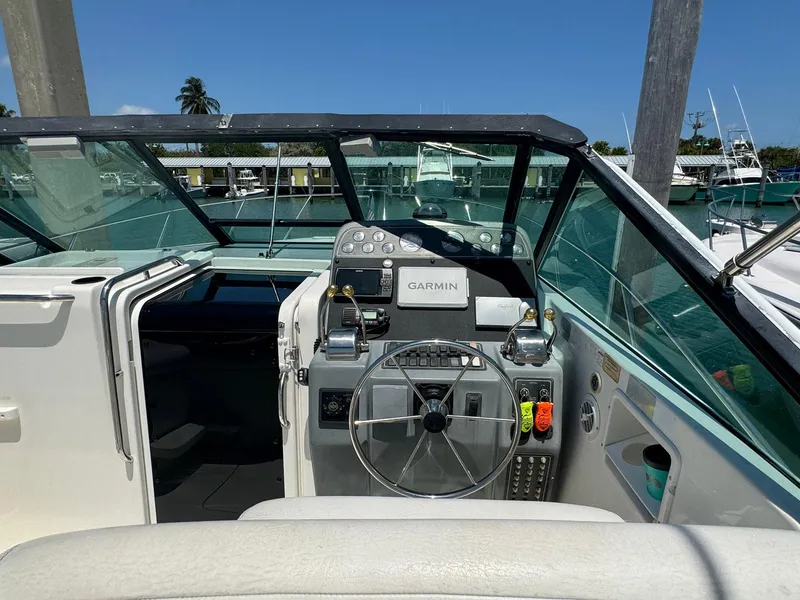 Slide: The Image of 2000 Tiara Yachts 3100 Open cockpit with Garmin navigation, docked in a sunny marina. - 38