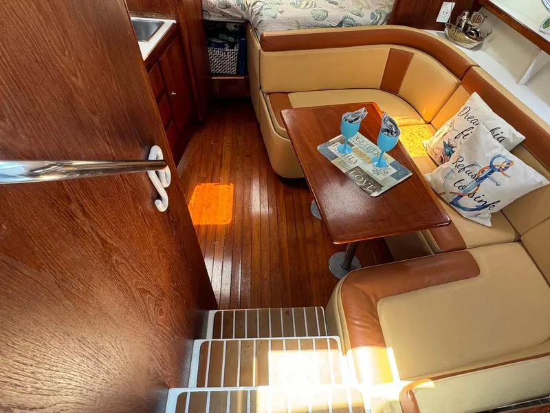 Slide: The Image of Interior of 2000 Tiara Yachts 3100 Open with cozy seating and wooden accents. - 4