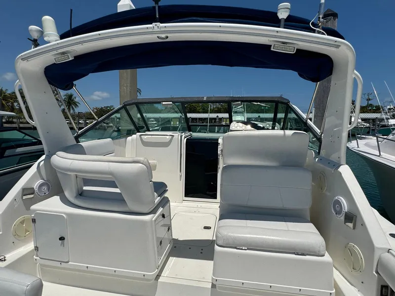 Slide: The Image of 2000 Tiara Yachts 3100 Open boat interior with white seating and blue canopy. - 45