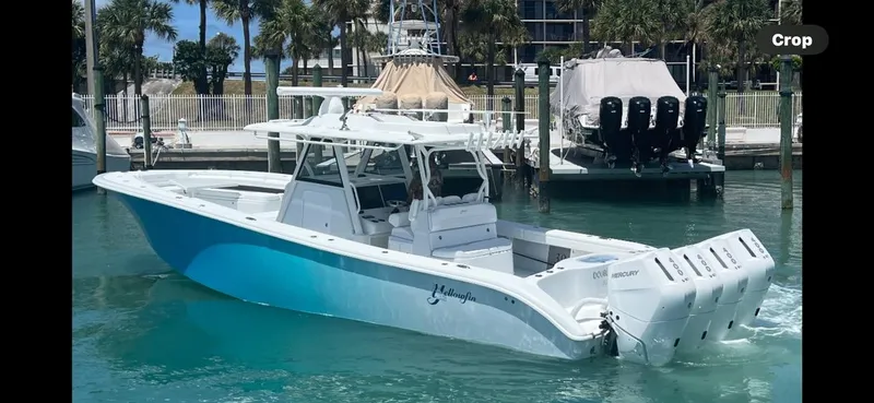 Slide: The Image of 2023 Yellowfin 39 Offshore boat docked in marina, clear blue water, palm trees in background. - 7