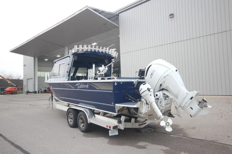 Slide: The Image of 2025 Weldcraft 240 Ocean King boat on trailer, Great Lakes Edition, parked outside a building. - 1