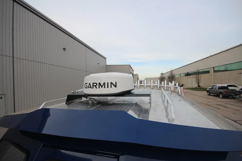 Slide: The Image of 2025 Weldcraft 240 Ocean King boat with Garmin radar, docked near industrial buildings. - 13