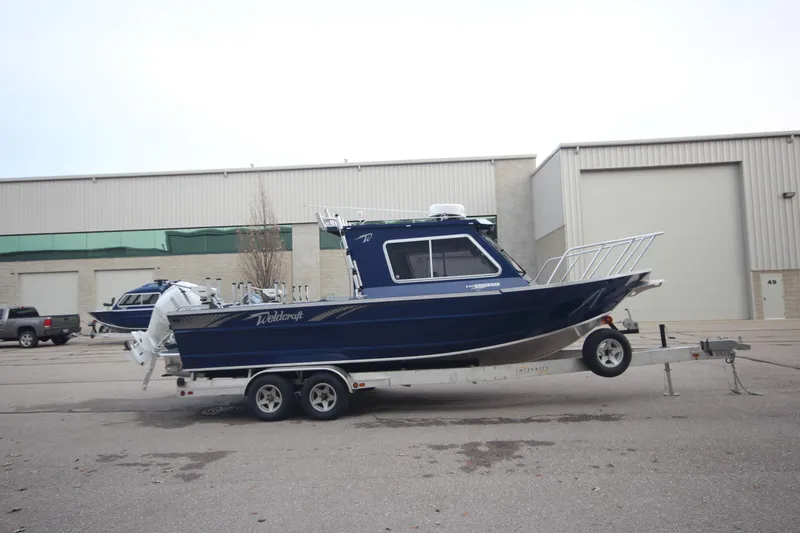 Slide: The Image of 2025 Weldcraft 240 Ocean King boat on trailer, parked outside industrial building. - 3
