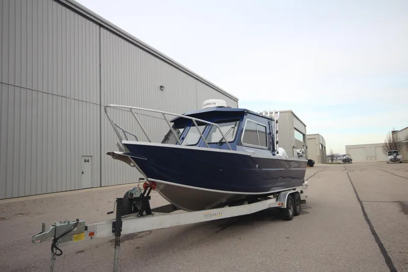Slide: The Image of 2025 Weldcraft 240 Ocean King boat on trailer, Great Lakes Edition, parked outside warehouse. - 4