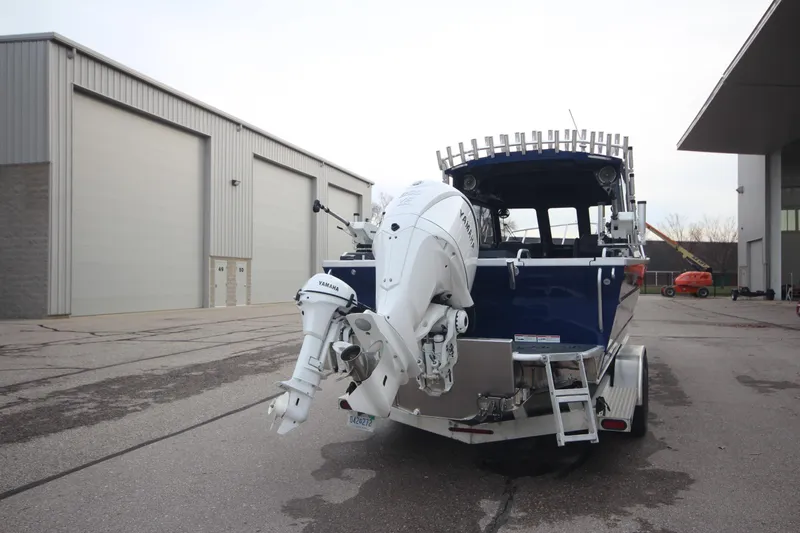 Slide: The Image of 2025 Weldcraft 240 Ocean King boat with outboard motor, parked outside a warehouse. - 6