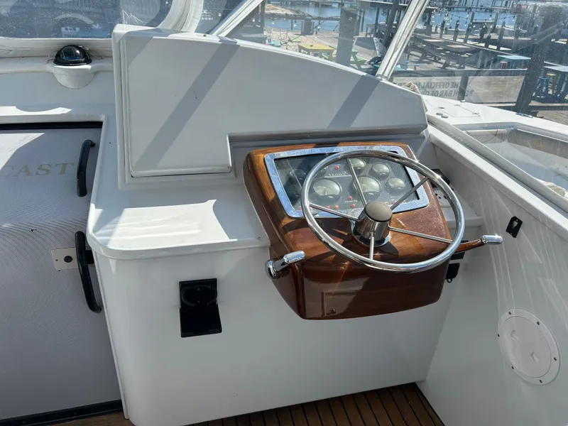 Slide: The Image of Helm of 2006 Miller 36 Express boat with wooden steering wheel and gauges. - 44