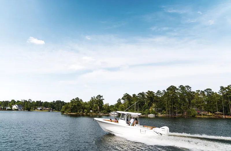 Slide: The Image of 2025 Sea Hunt Ultra 305 SE boat cruising on a scenic lake. - 12
