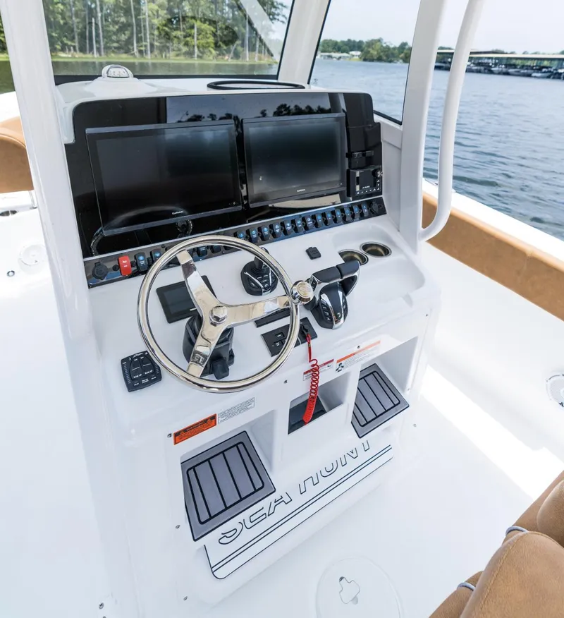 Slide: The Image of 2025 Sea Hunt Ultra 305 SE boat dashboard with dual screens and steering wheel. - 14