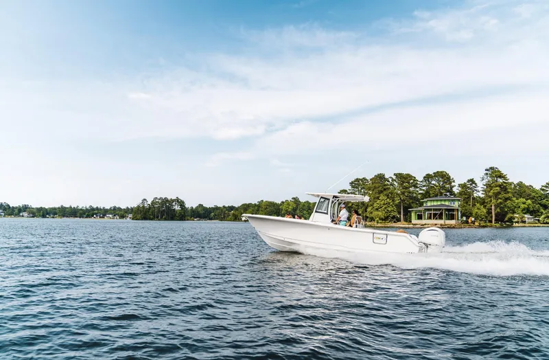 Slide: The Image of 2025 Sea Hunt Ultra 305 SE cruising on a scenic lake. - 15