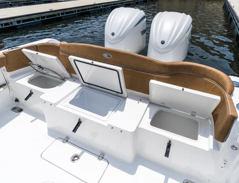 Slide: The Image of 2025 Sea Hunt Ultra 305 SE boat with open storage compartments and twin engines. - 16