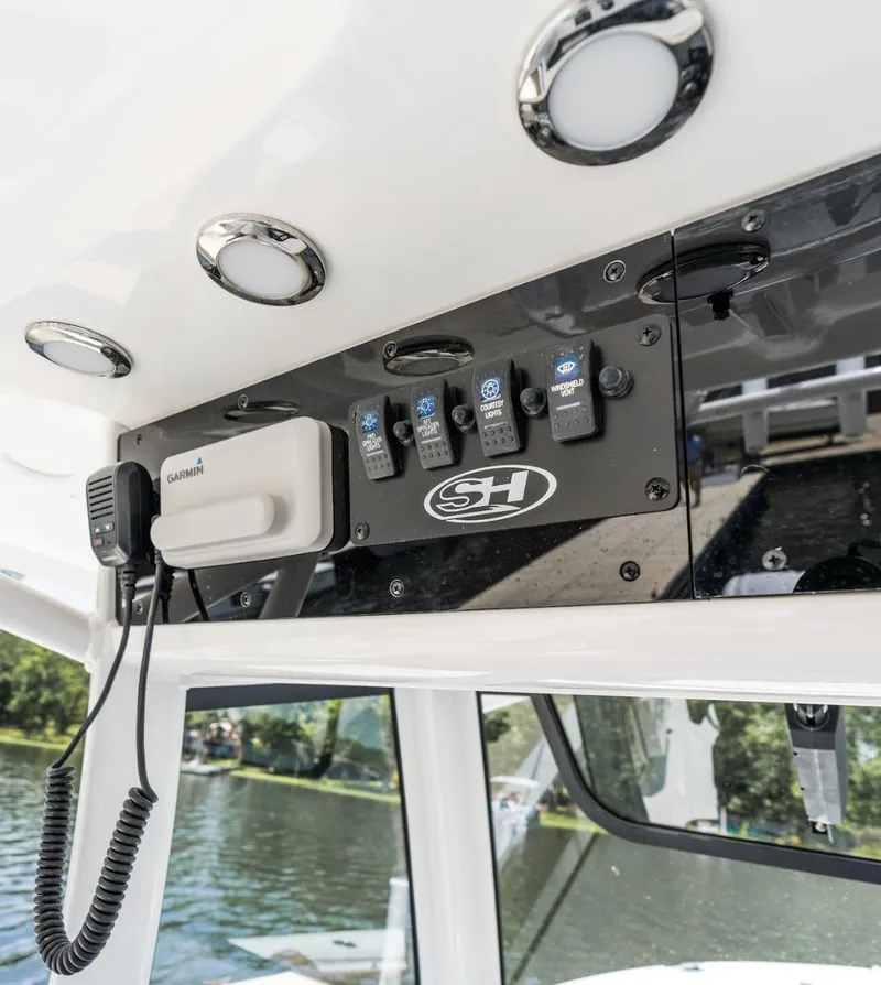 Slide: The Image of 2025 Sea Hunt Ultra 305 SE boat dashboard with controls and Garmin device. - 20