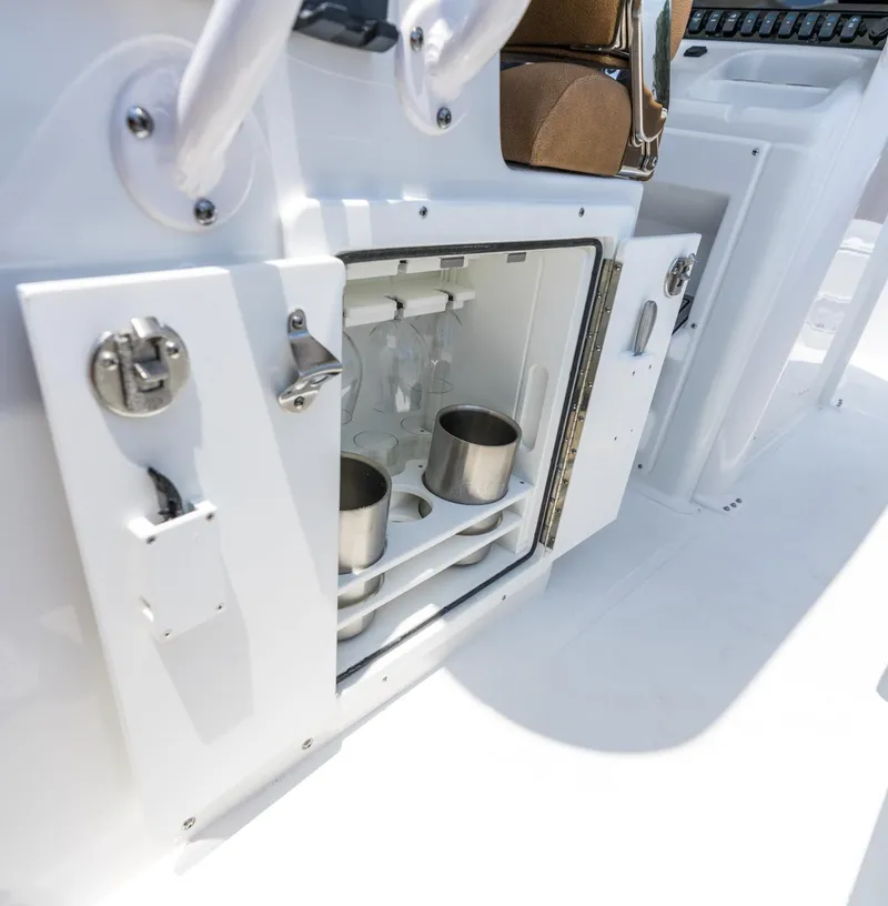 Slide: The Image of 2025 Sea Hunt Ultra 305 SE boat interior with open storage compartment and cup holders. - 21